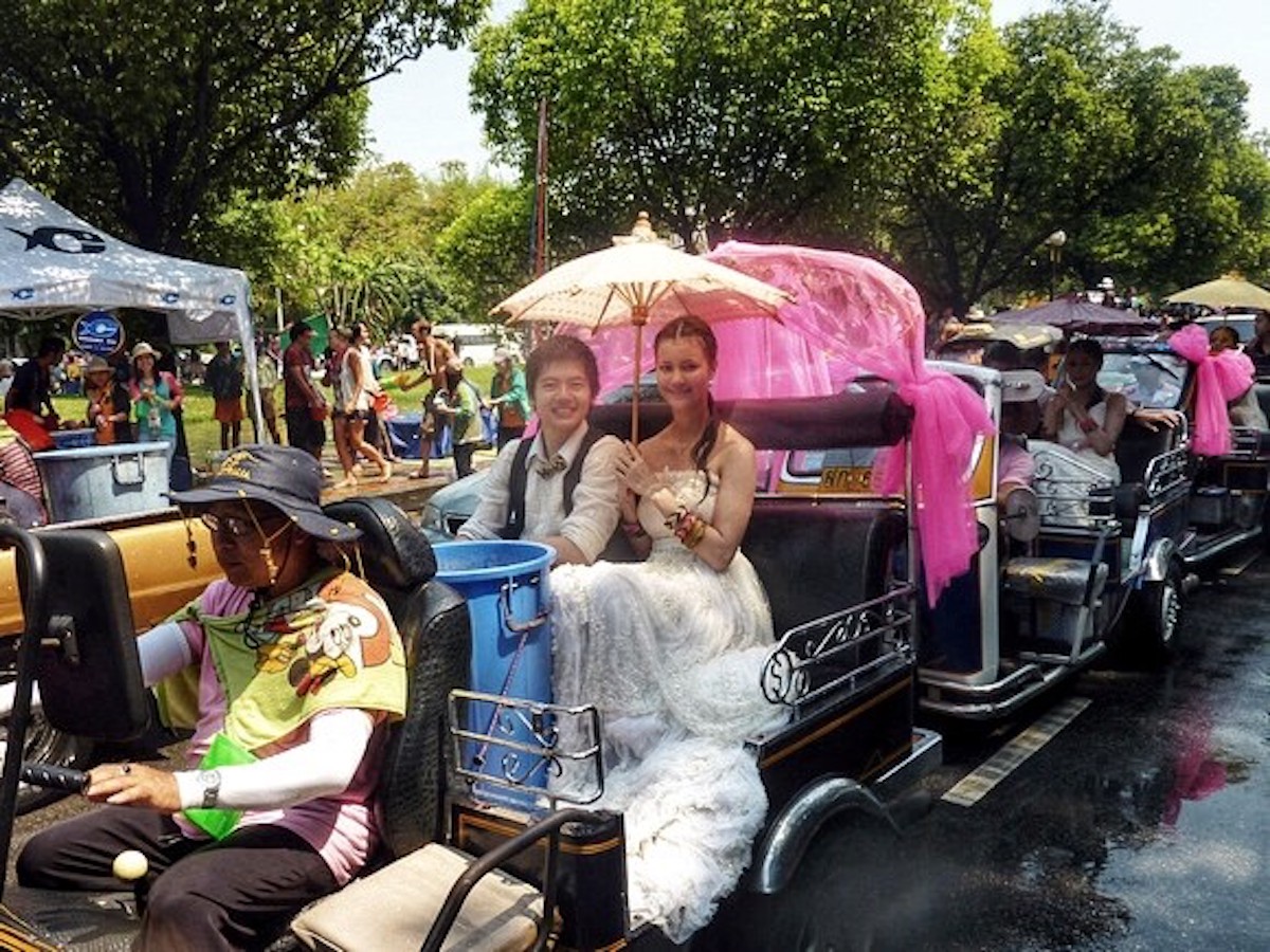 A boy and girl smile at a religious ceremony in Thailand.