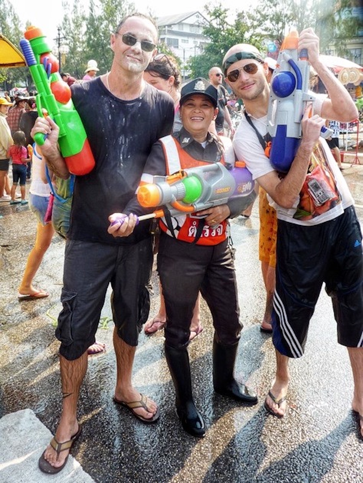 A policewoman poses with tourists in Thailand.