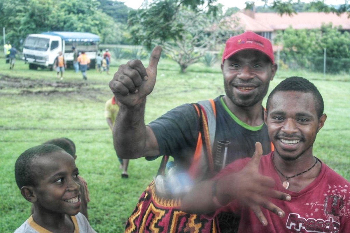 2 men and a boy smiling in Papua New Guinea 