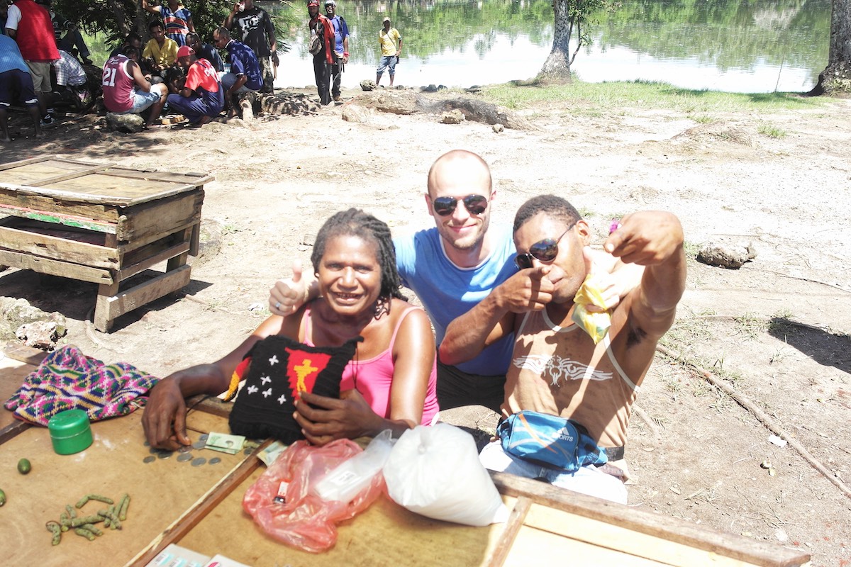 Tourist poses with locals in Papua New Guinea