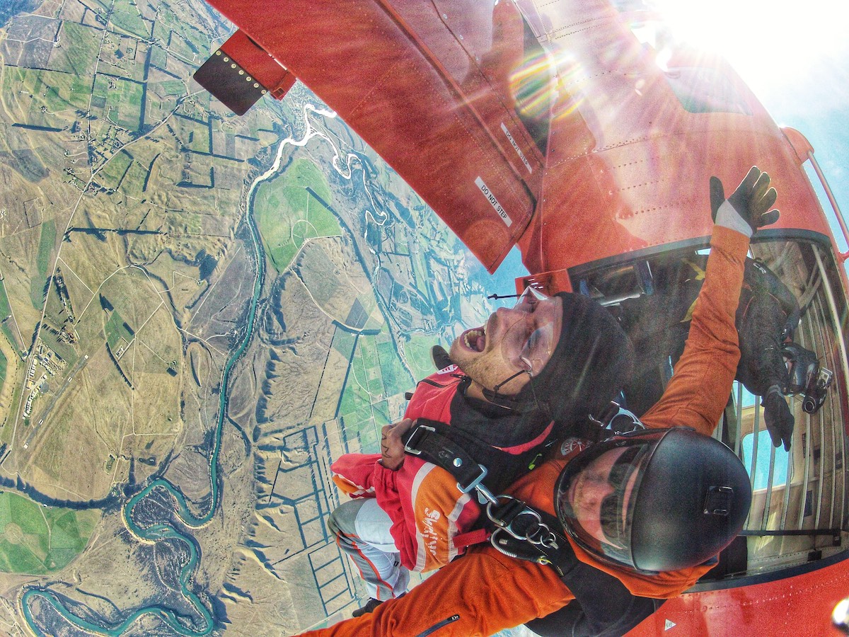 A man screams as he jumps out of skydiving plane.