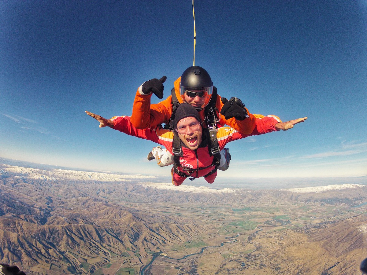 2 men pose for the camera during a skydive.