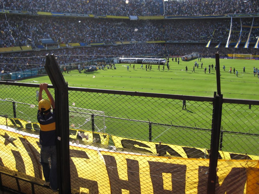 A young Boca Juniors fan watches his team play at La Bombonera Stadium