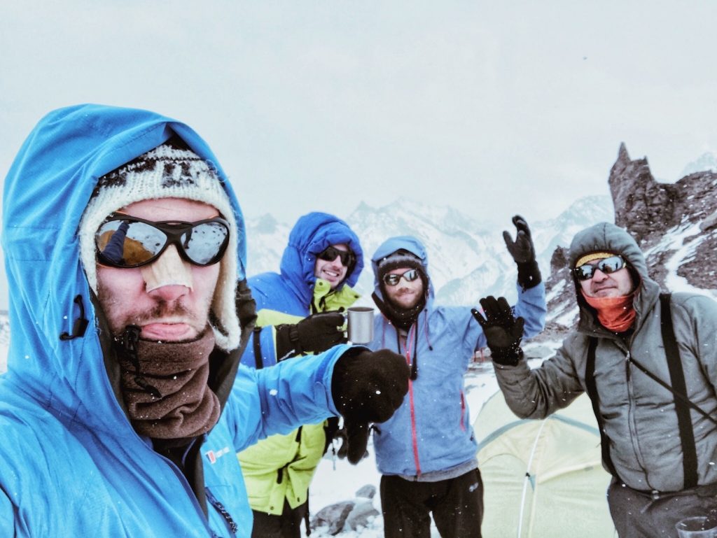 Male mountain climbers drinking tea at camp during a blizzard on Aconcagua