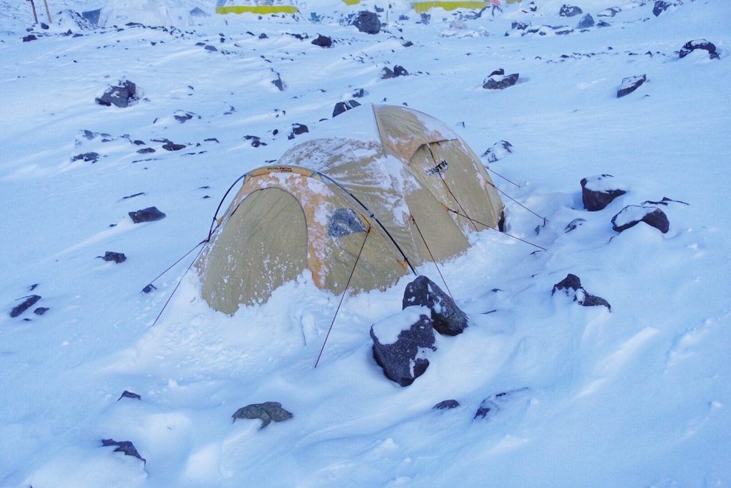 A yellow snow-covered tent on Aconcagua during a failed attempt due to unprecedentedly dangerous weather