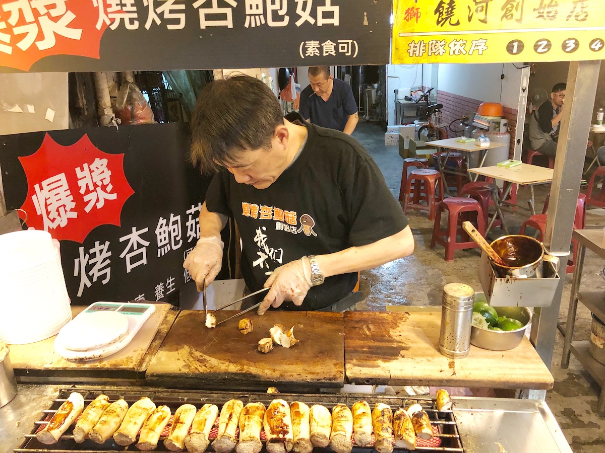 A male street-seller chops up mushrooms to sell in Taipei, Taiwan