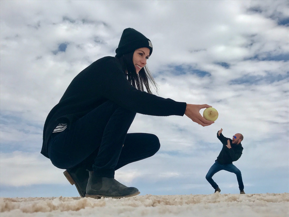 A giant lady offers a disturned man an onion in Salar de Uyuni, Bolivia.