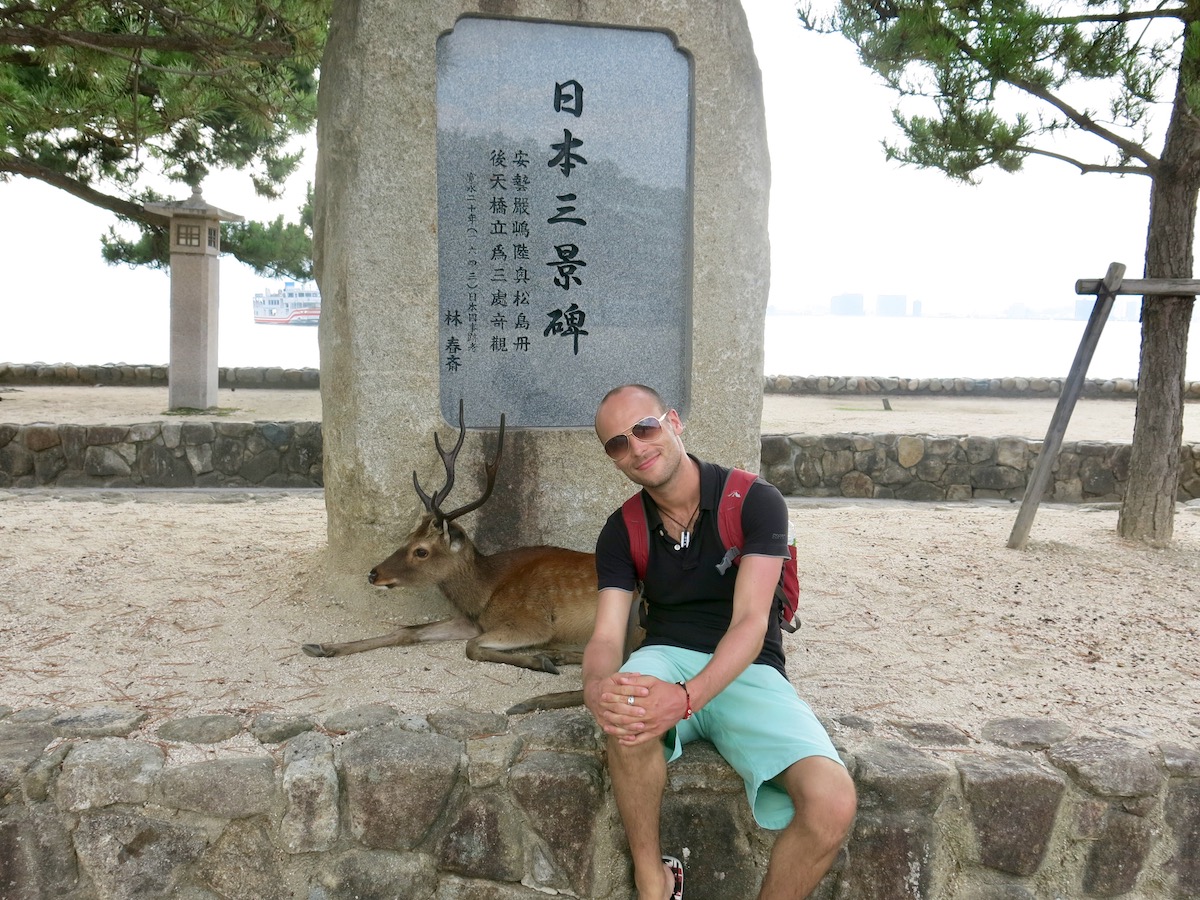 Tourist poses with deer in national park