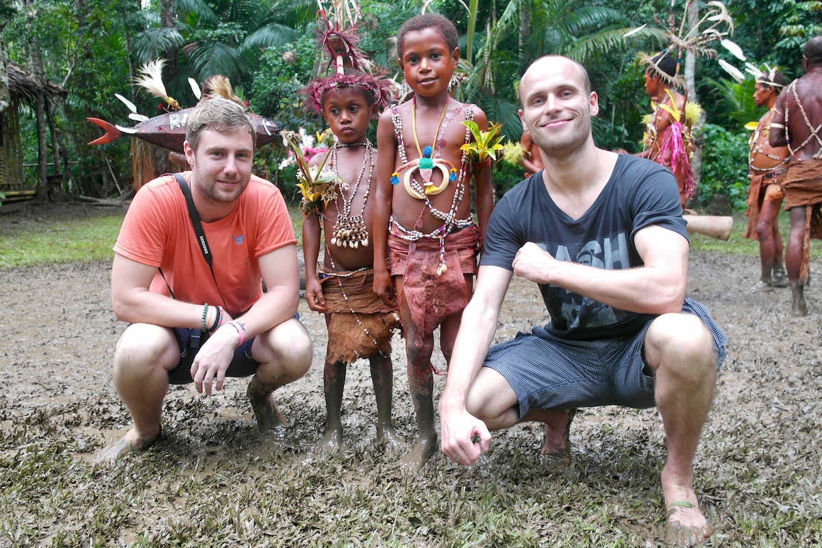 Male tourists with young tribespeople in Papua New Guinea