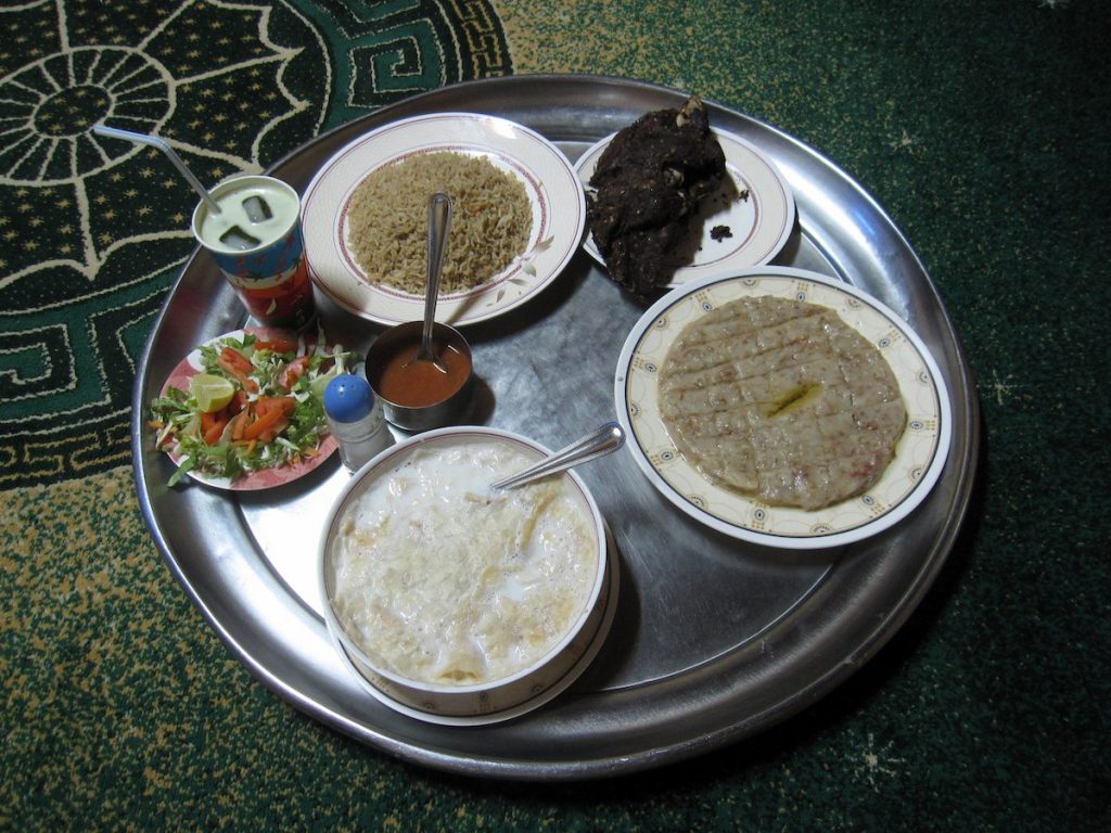 Traditional Omani cuisine with meat, pancakes and sweet bread pudding