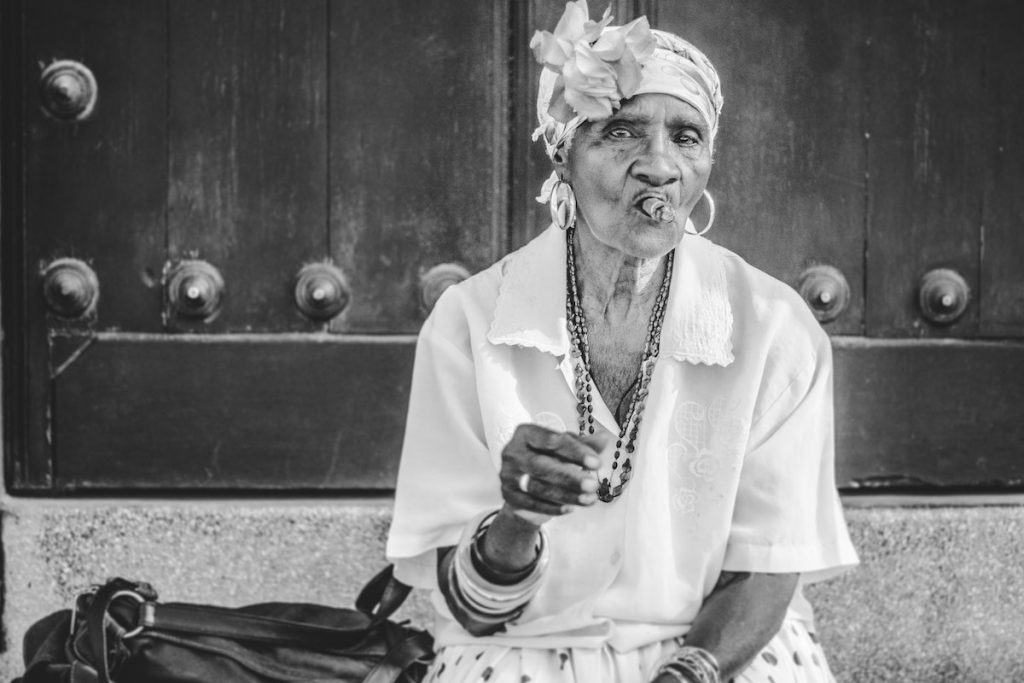 Old Cuban lady calmly smoking a cigar in Havana, Cuba