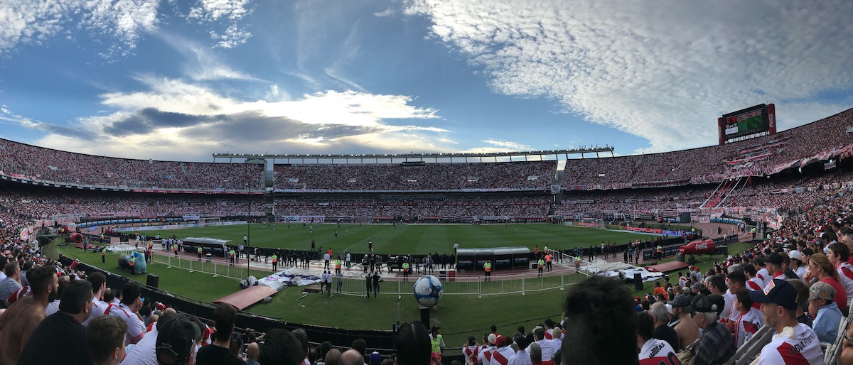 Panoramic pitch side view on a clear day during a football match in Argentina.