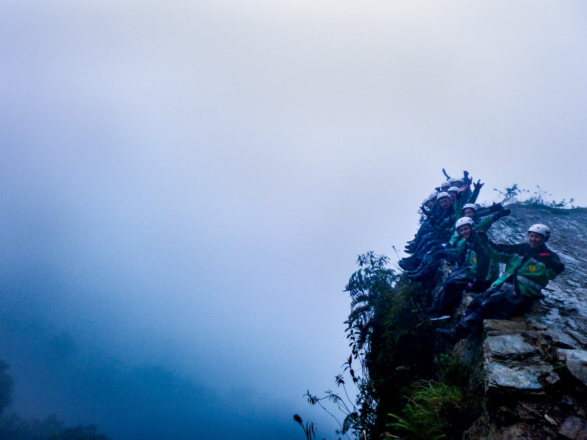Tourists pose on the edge of the Bolivian Death Road cliff on a foggy day outside of La Paz.
