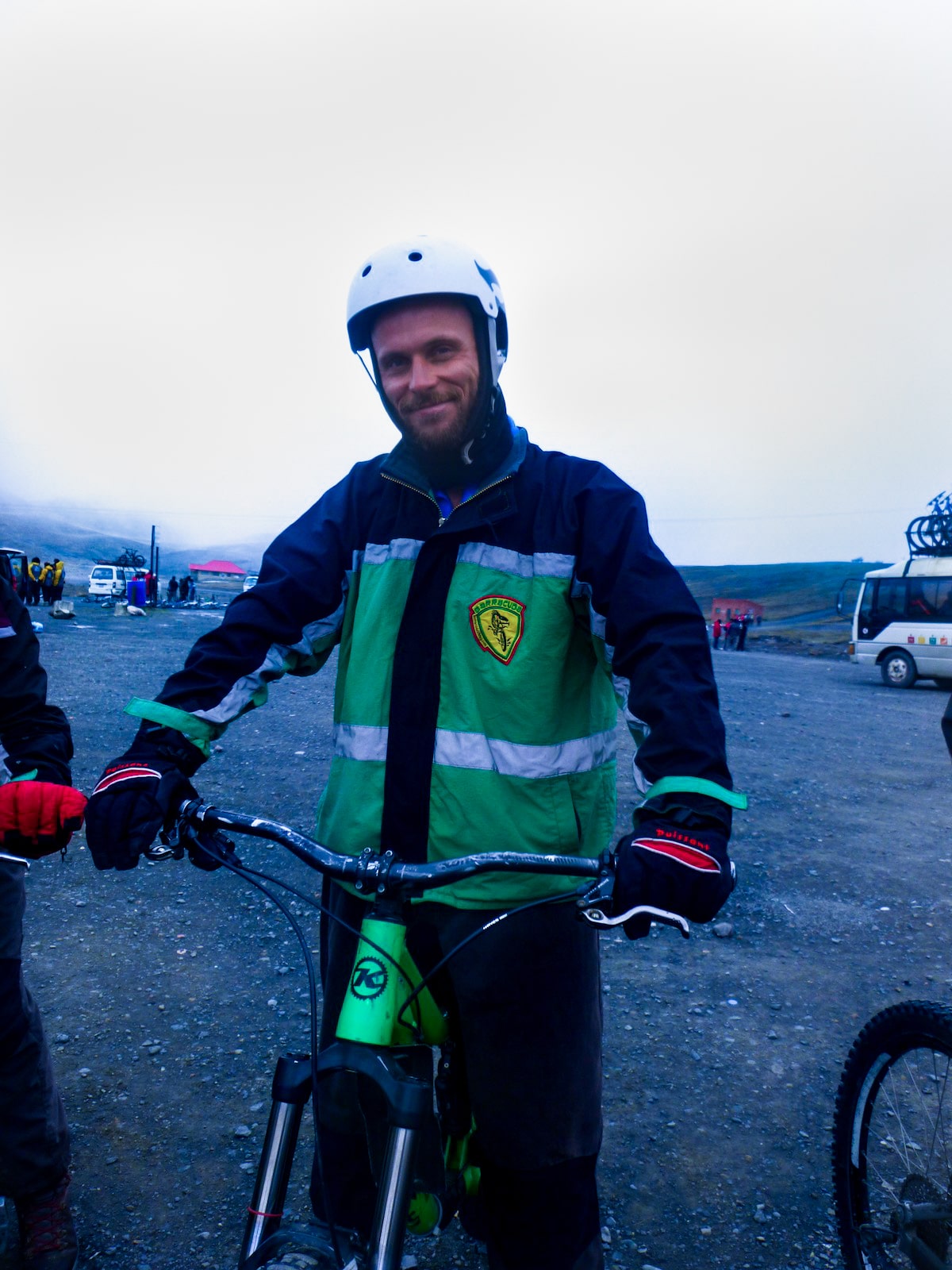 Male cyclist in green smiles on his bike in La Paz, Bolivia.