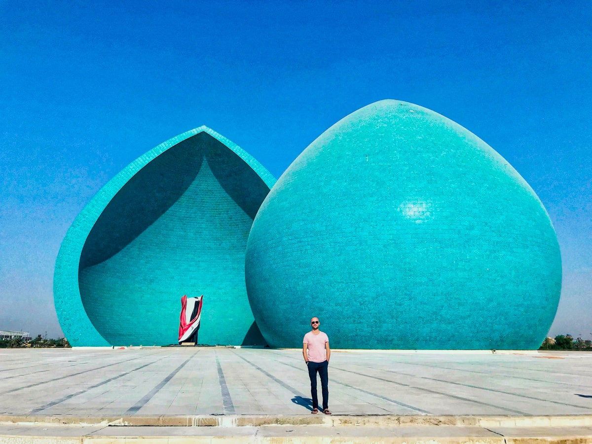 A tourist stands at the Al Shaheed Martyrs Monument Baghdad