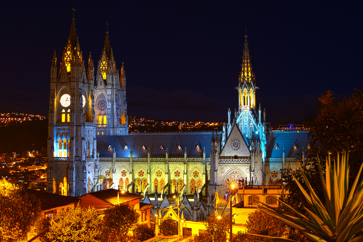 A gothic building lit up at night in Quito, Ecuador.