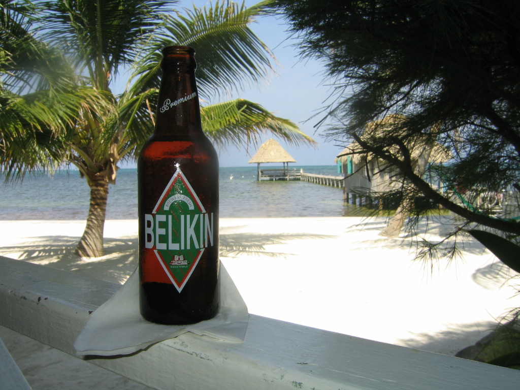 A bottle of Belikin Beer overlooks the beach.