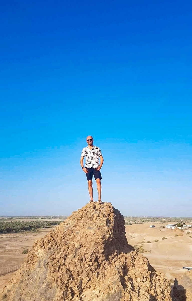 A man stands on a large rock in Babylon, Iraq