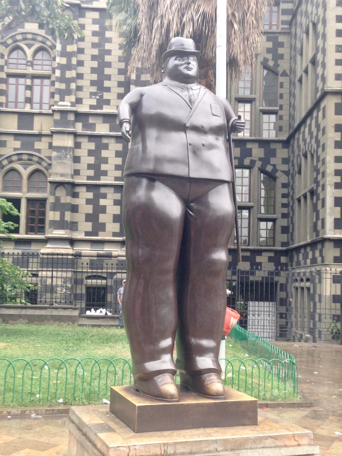 A statue of a chubby man in a bowler hat