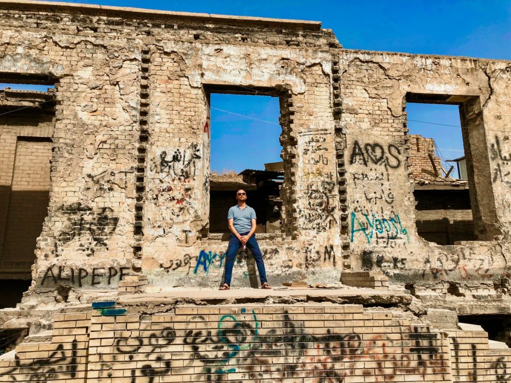A male tourist poses at British Club Ruins during is 4 days in Baghdad