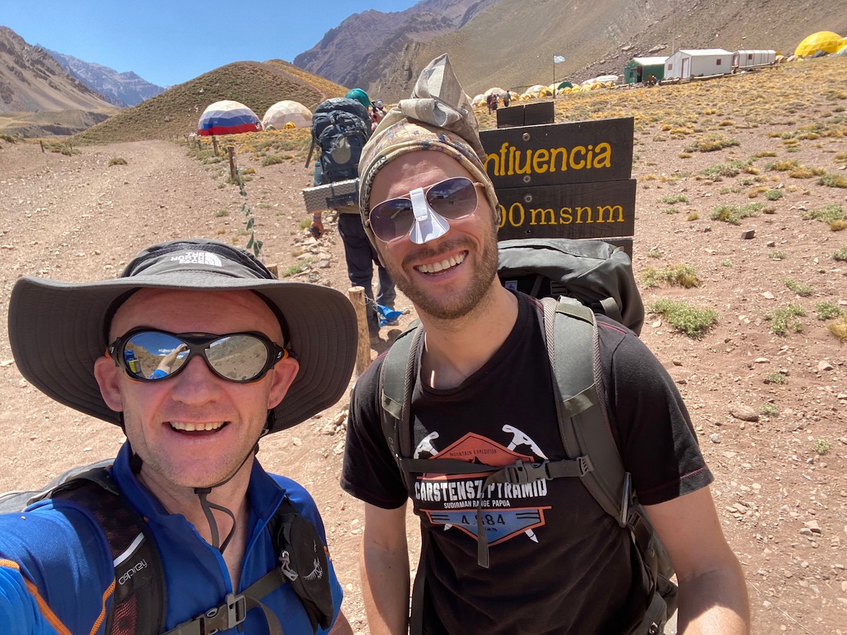 Two hikers smile at Camp Confluencia during an Aconcagua hike