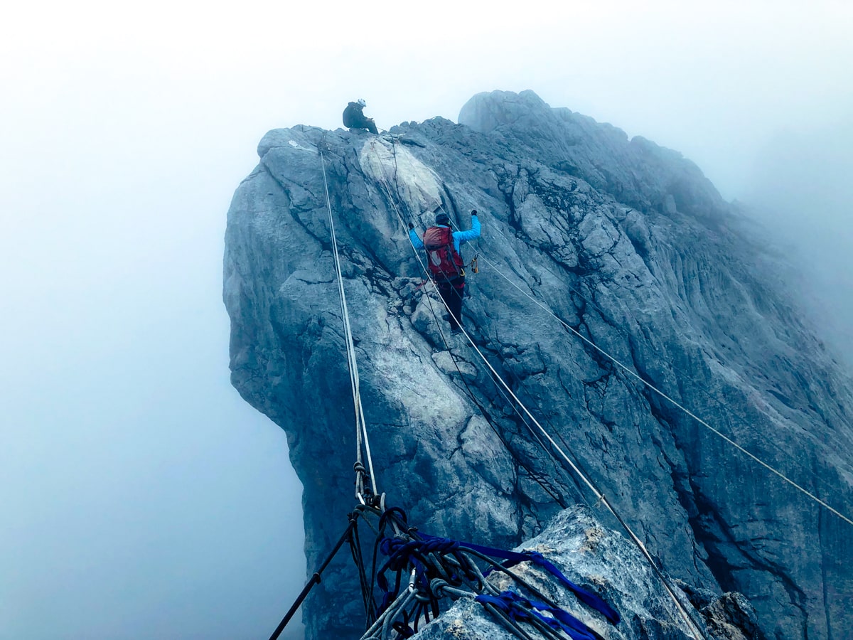 A female climber walks the infamous scary Rope Bridge on Puncak Jaya, also known as Carstenz Pyramid.