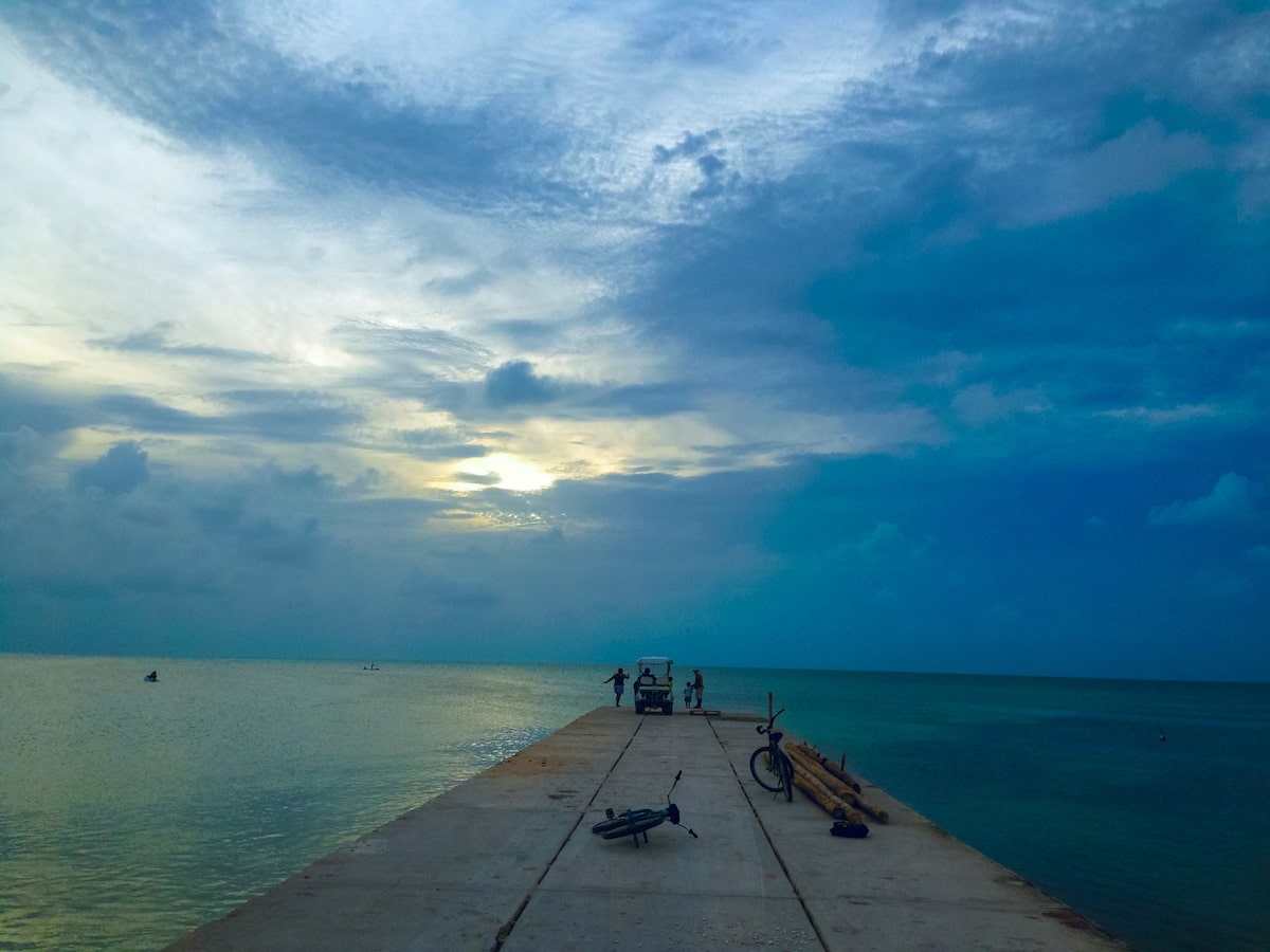 2 bikes lie on a beach pier at dawn. 