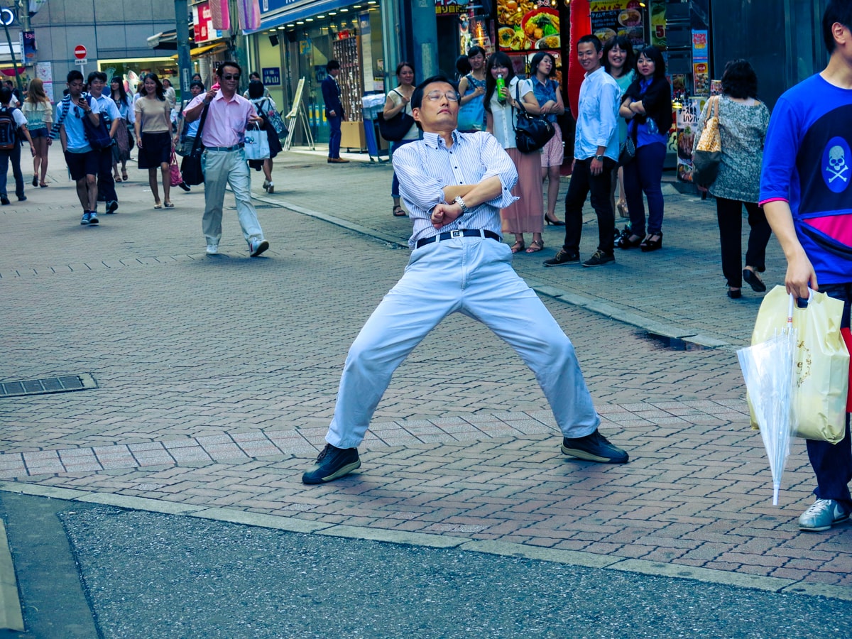 A weird Japanese man pulls a pose in the streets of Tokyo