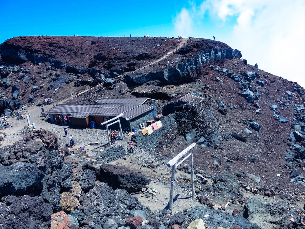 A high-up view of a black mountain, busy with tourists.