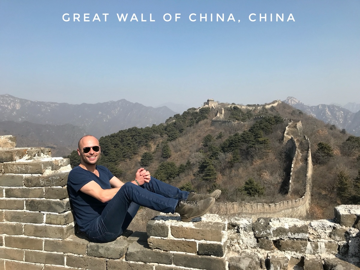 A male tourist poses on a messy part of the Great Wall of China