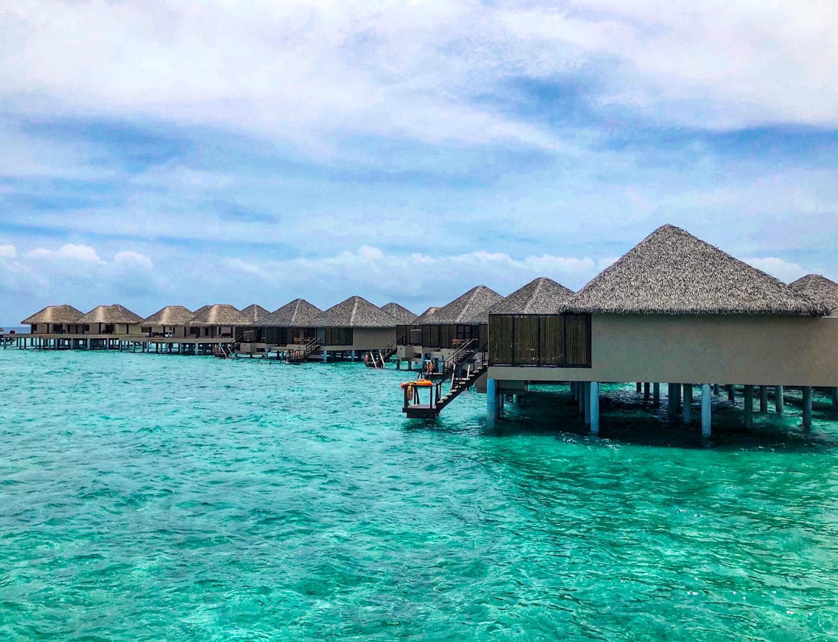 A landscape view of water bungalows in a Maldives resort overlooking turquoise blue sea