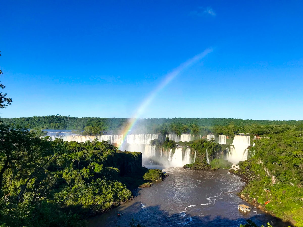 A beautiful landscape view of a rainbow going over Brazil Iguazu Falls