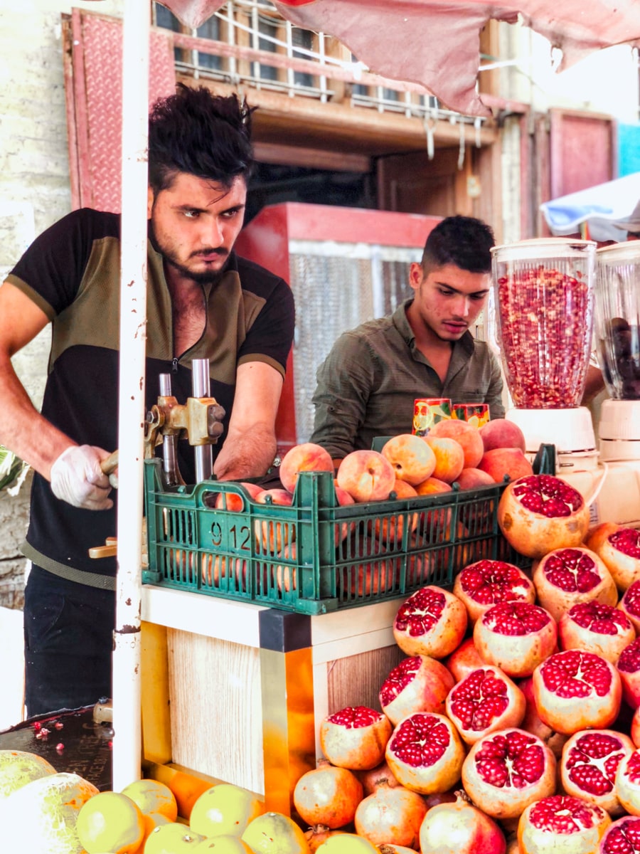 A fruit vendor in Baghdad squeezes pomegranates to make into a juice