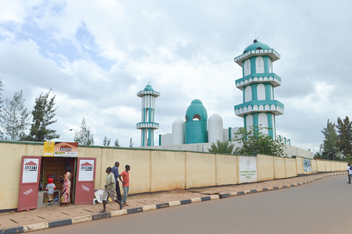 People stand outside a blue and white mosque in Kigali, Rwanda