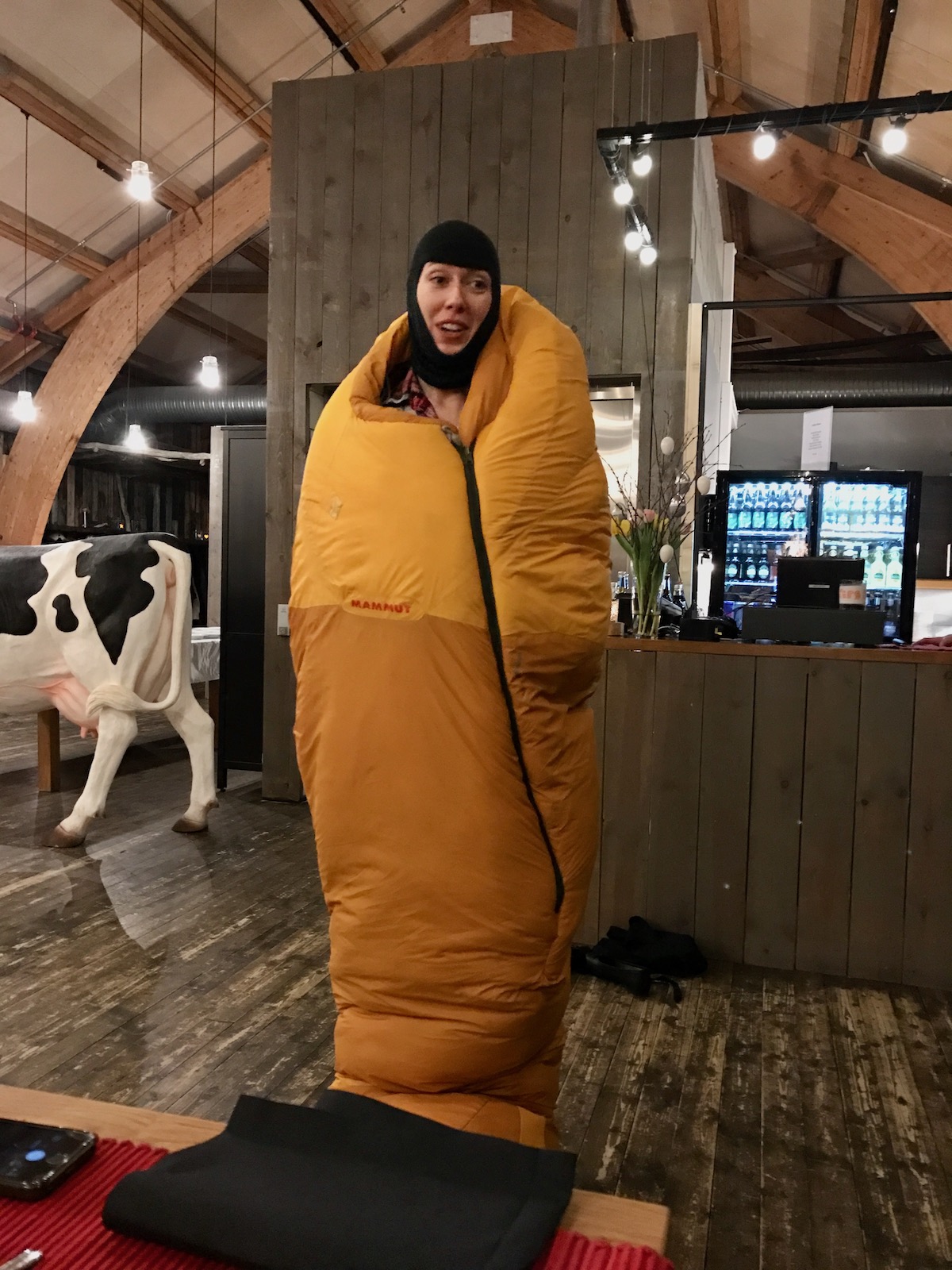 A female guide wrapped in a sleeping bag explains how to stay warm while sleeping in an ice hotel in Norway