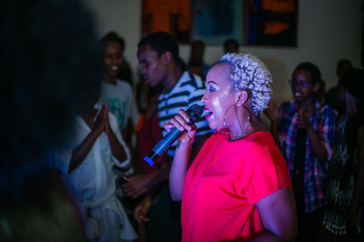 A lady sings into a microphone in Kigali