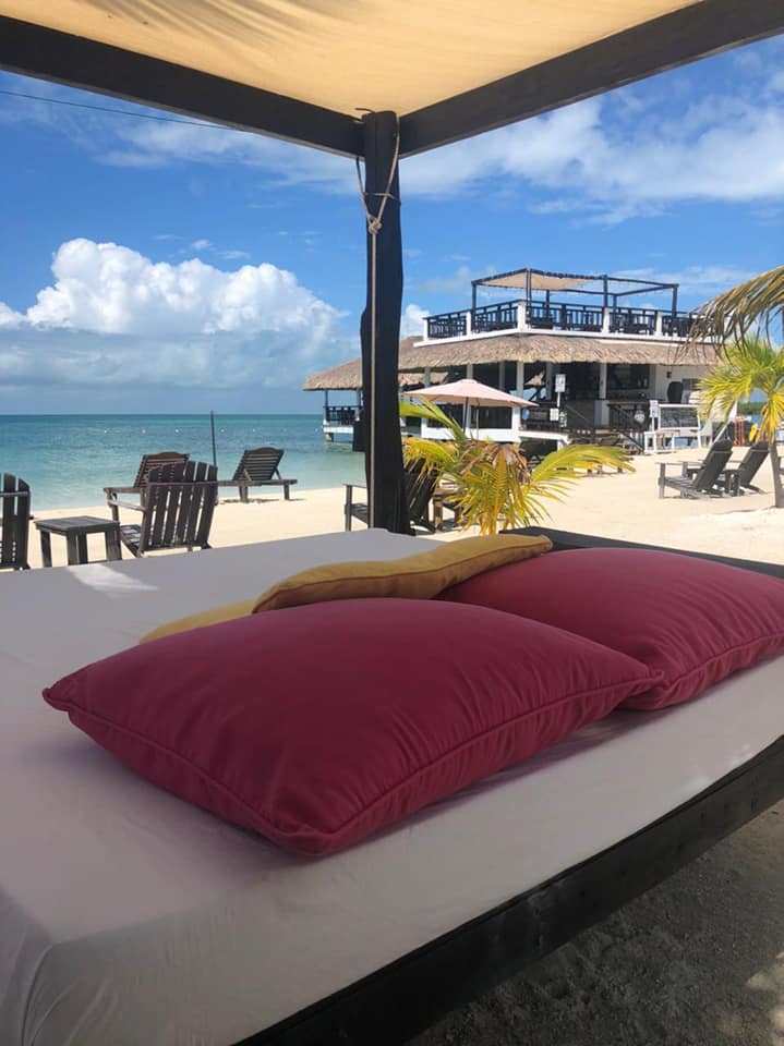 Sunbeds overlooking the beach on a bright blue day in Caye Caulker, Belize