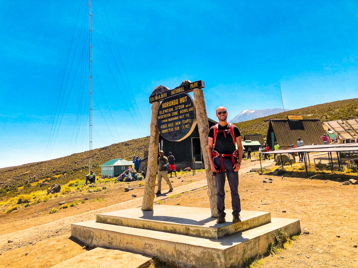 Tourist at a sign reading "Horombo Hut."