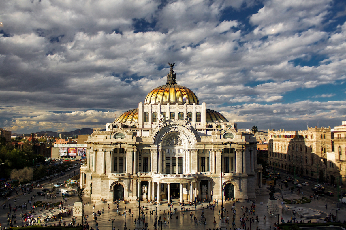 A large gold-domed building during the day in Mexico City