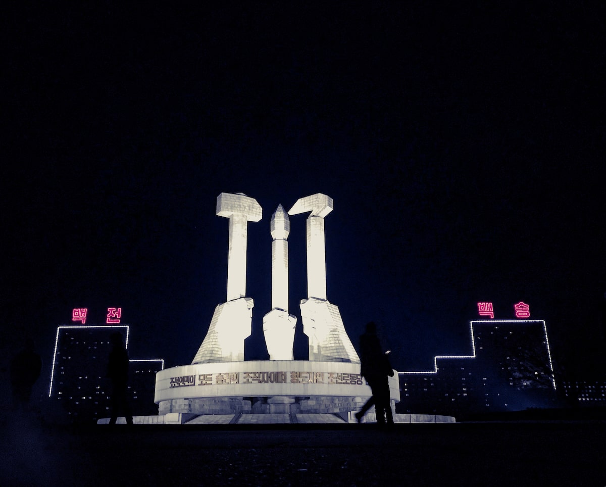 A striking Sovietesque Monument To The Korean Workers Party is lit up at night time in Pyongyang, the capital of North Korea