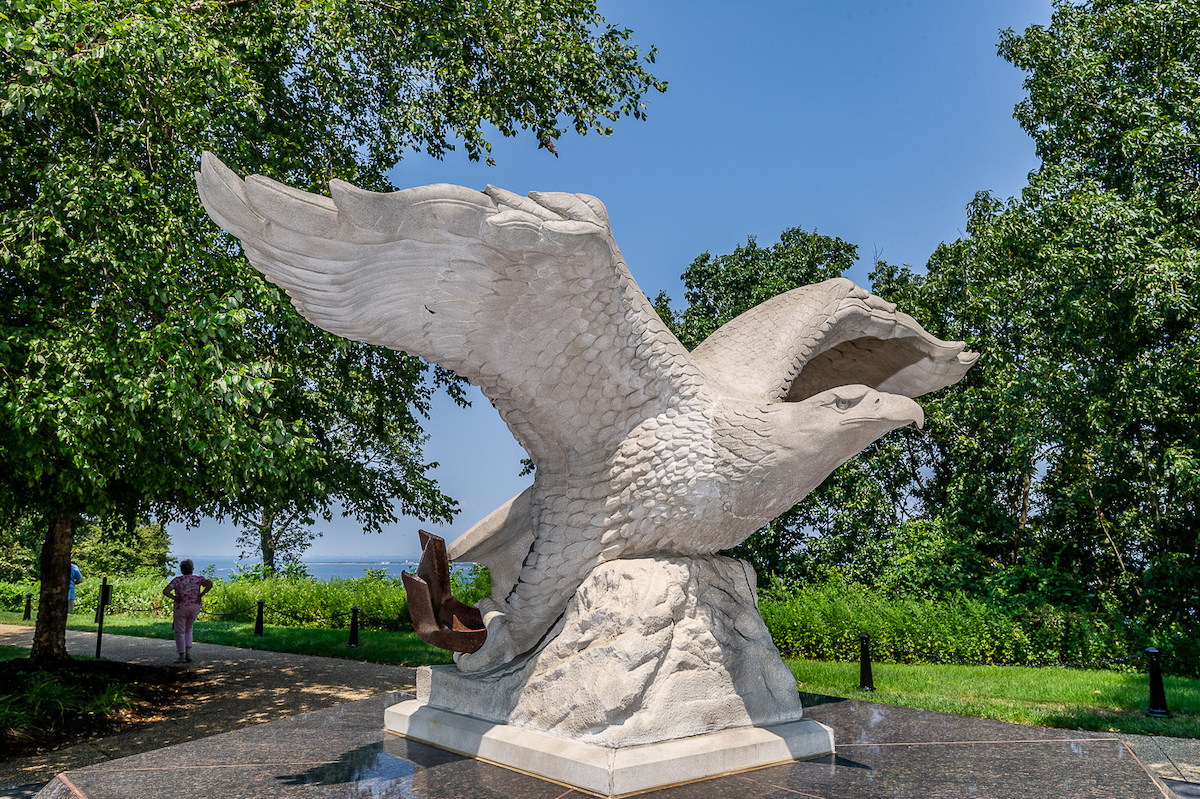 A large sculpture of a white stone eagle spreading its wings 