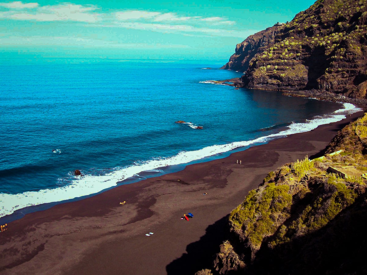 A brown-sanded beach with cliffs in Cuba.