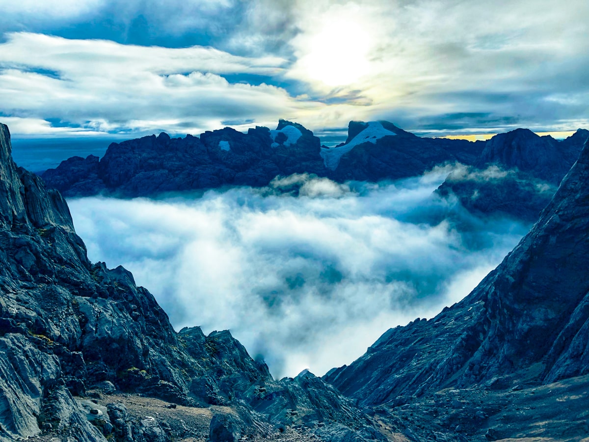 Moody clouds hang over the horizon of a cloud-filled mountain in Puncak Jaya, Indonesia.