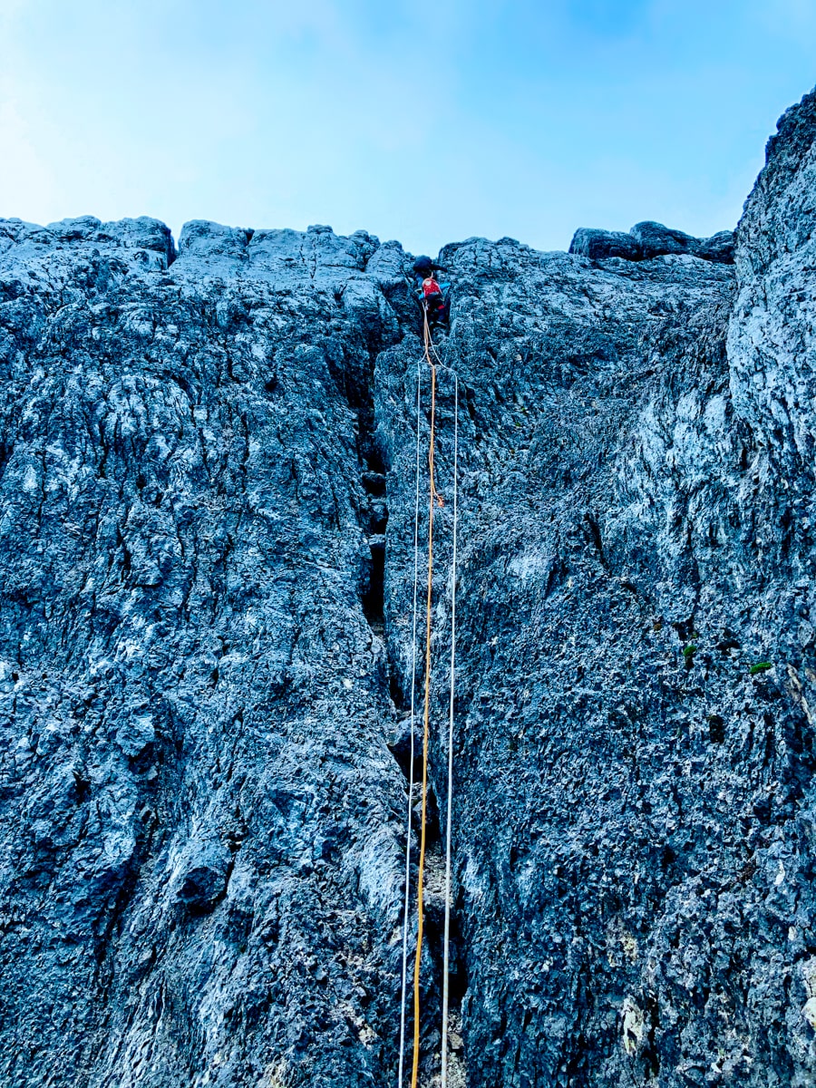 A climber abseiling up Puncak Jaya