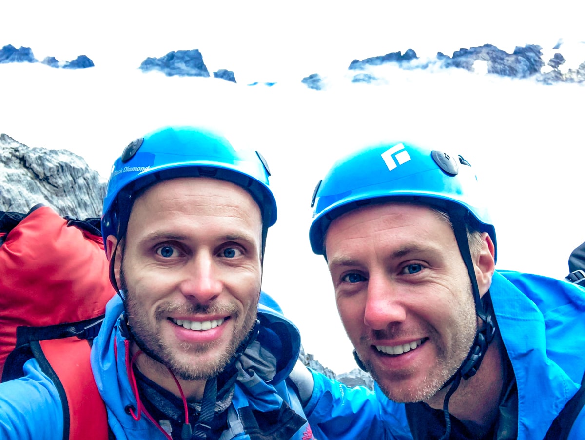 Two male climbers smile while climbing Puncak Jaya
