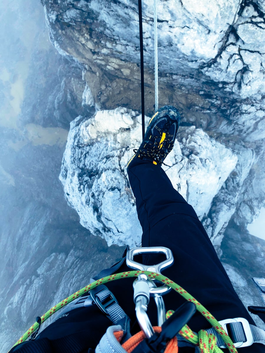 View below a man stepping over a rope on Puncak Jaya mountain