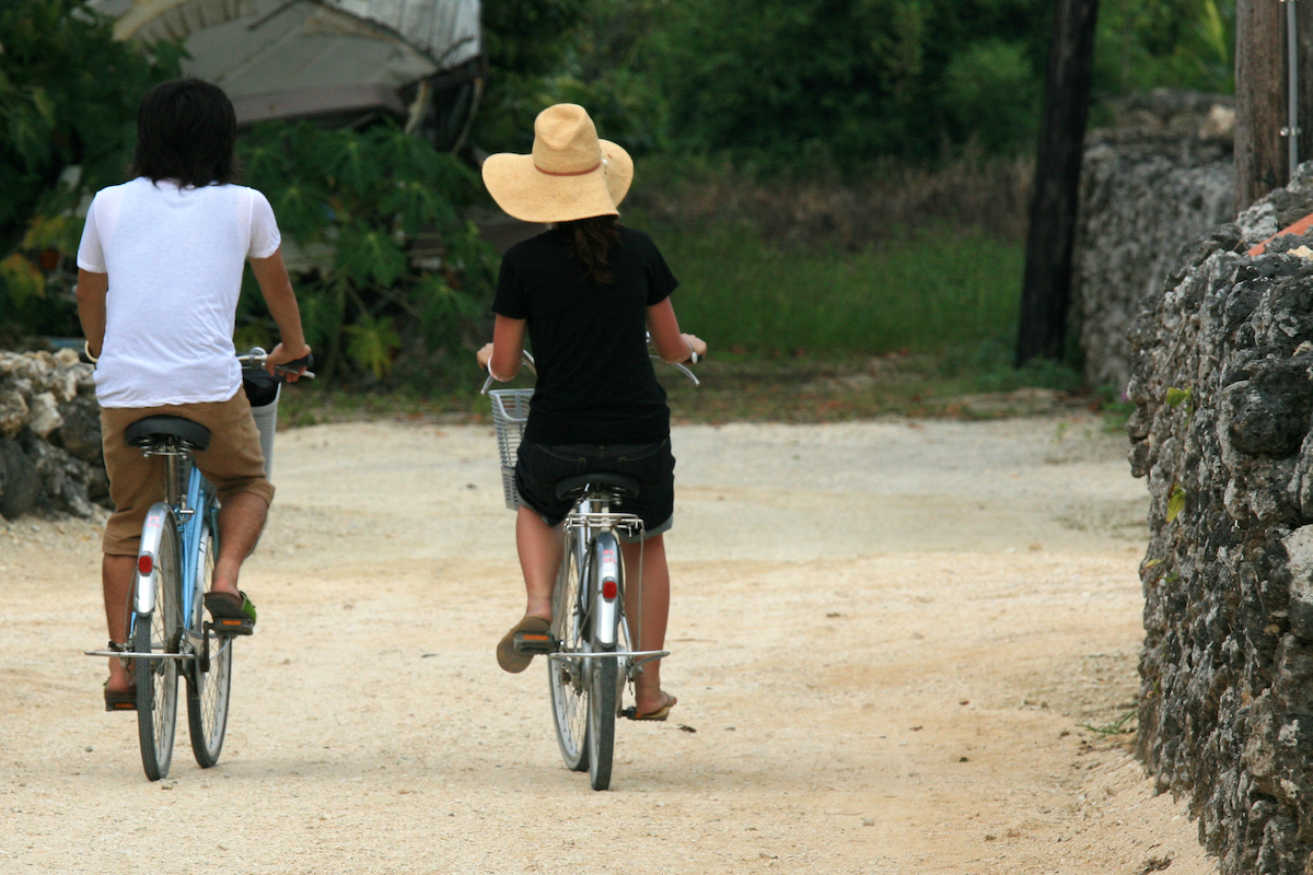 Locals riding a bike in Taketomi Island, Okinawa, Japan