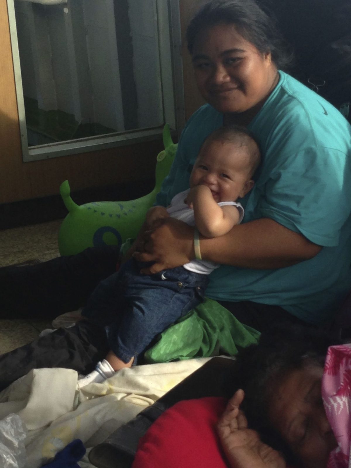 Mother and child smile while sitting on the ground