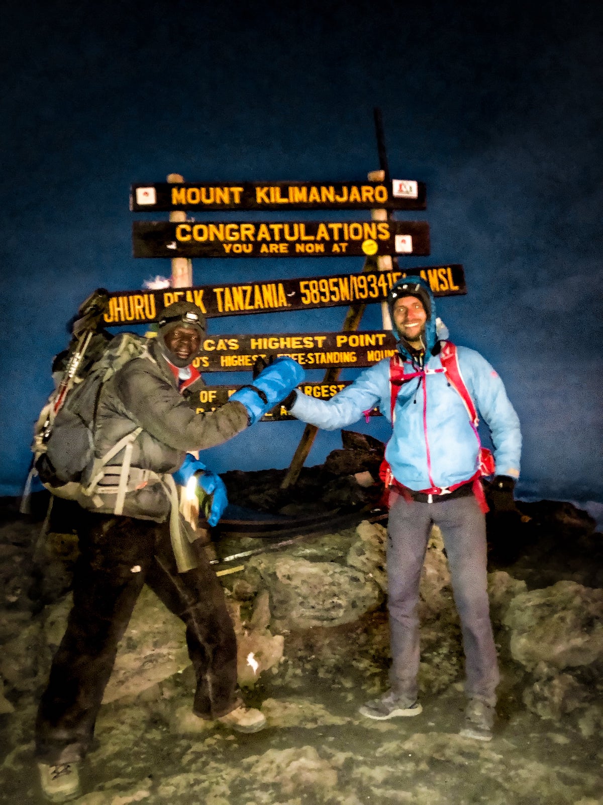 Two men shake hands on the summit of Mount Kilimanjaro in Tanzania, East Africa.