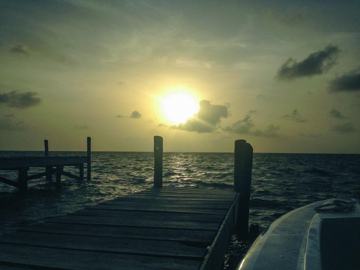 The sun shines over a pier in Caye Caulker, Belize. 